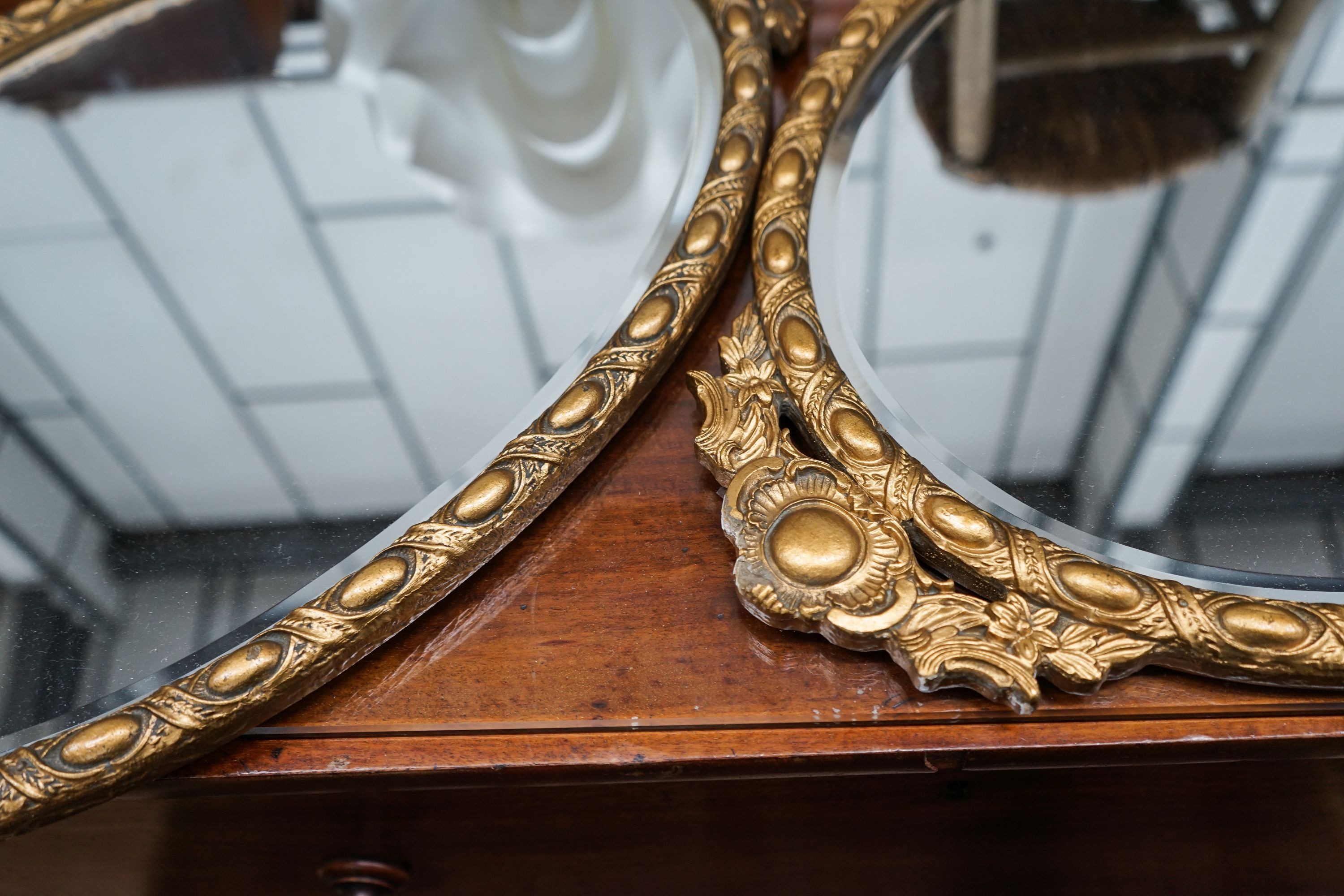 A pair of oval gilt framed wall mirrors inset porcelain plaques, width 42cm, height 78cm